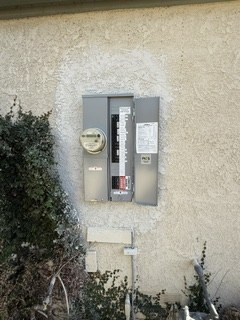 Exterior main panel and meter on a stucco wall