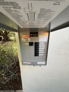 Outdoor subpanel with breakers and an open protective cover