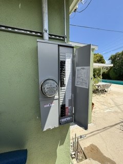 Main panel and meter installation on a green stucco wall
