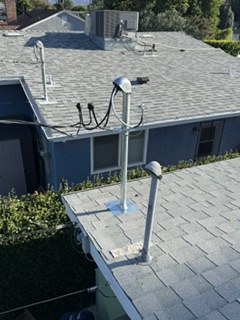 Rooftop view of an electrical service mast and weatherhead