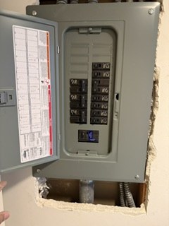 Open indoor subpanel with breakers and a circuit directory