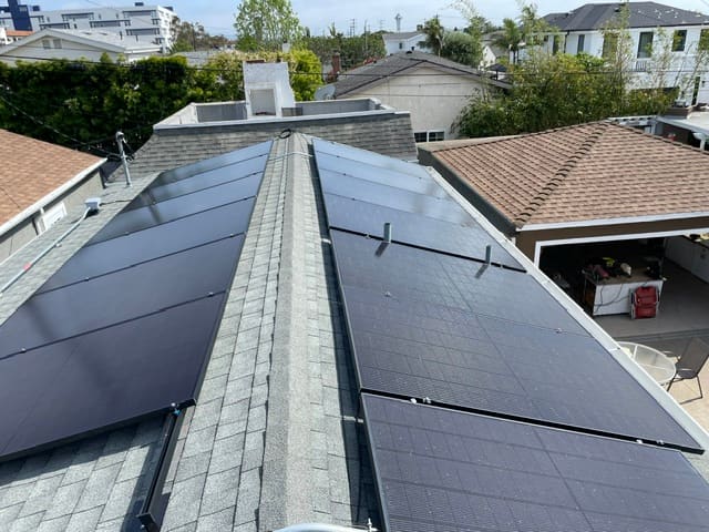 Solar arrays installed on both sides of a roof ridge