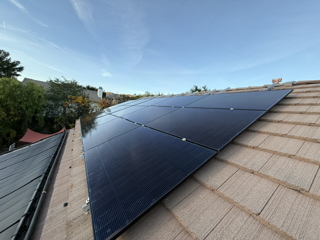 Close view of a completed solar panel array on a tiled roof